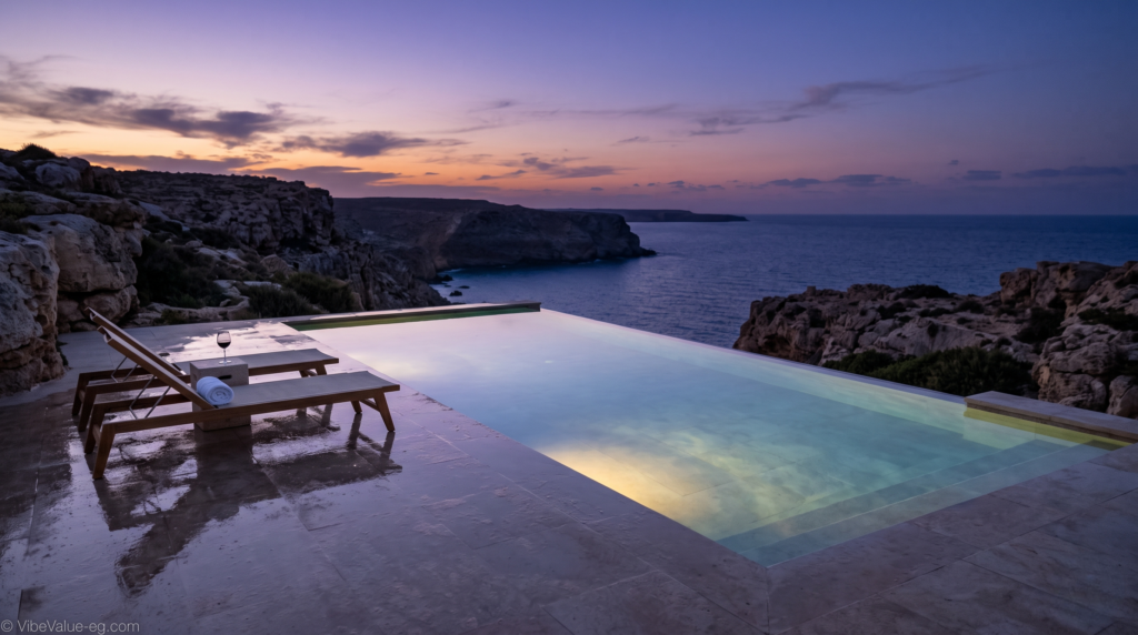 A secluded infinity pool at dusk on the Ageeba Plateau, merging with the Mediterranean Sea, symbolizing high-net-worth leisure © VibeValue-eg.com